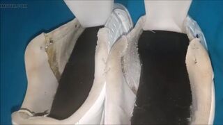 "A pair of white Adidas sneakers worn by a beautiful preppy girl."