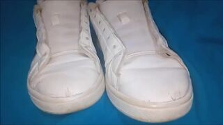 "A pair of white Adidas sneakers worn by a beautiful preppy girl."